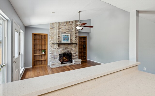 2848 Oxford Ln, Flower Mound, TX 75028 - living room with lofted ceiling, wood finished floors, ceiling fan, a brick fireplace, and baseboards