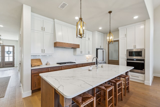 3812 Outpost Trl, Mckinney, TX 75071 - kitchen with stainless steel appliances, a chandelier, decorative backsplash, custom range hood, and recessed lighting