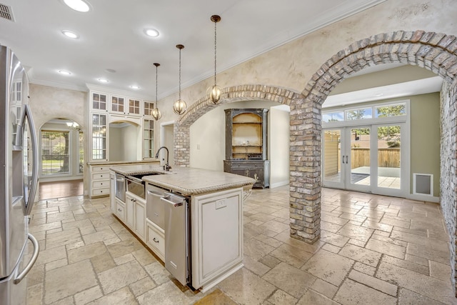 1700 Tall Timber Dr, Tyler, TX 75703 - kitchen featuring a sink, stone tile flooring, recessed lighting, stainless steel appliances, and arched walkways