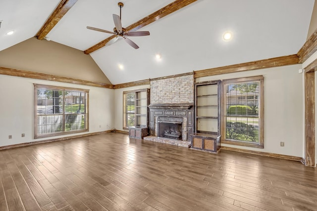 1700 Tall Timber Dr, Tyler, TX 75703 - unfurnished living room with beam ceiling, a ceiling fan, baseboards, a brick fireplace, and wood finished floors
