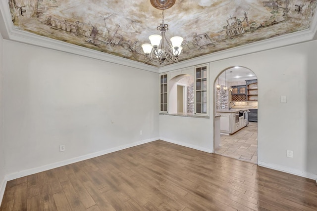 1700 Tall Timber Dr, Tyler, TX 75703 - empty room featuring a chandelier, crown molding, baseboards, a tray ceiling, and arched walkways