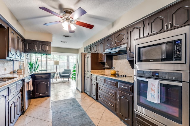 109 Tuscany Ct, Irving, TX 75062 - kitchen with appliances with stainless steel finishes, under cabinet range hood, dark brown cabinets, ceiling fan, and backsplash
