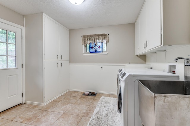 109 Tuscany Ct, Irving, TX 75062 - clothes washing area featuring cabinet space, a textured ceiling, light tile patterned flooring, washer hookup, and baseboards