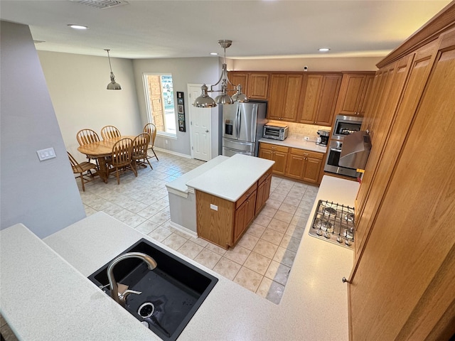 kitchen with appliances with stainless steel finishes, brown cabinetry, light tile patterned floors, light countertops, and recessed lighting