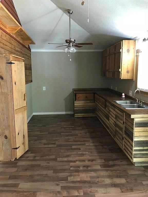 509 W Sears St, Denison, TX 75020 - kitchen featuring a sink, lofted ceiling, a ceiling fan, dark wood-style floors, and baseboards