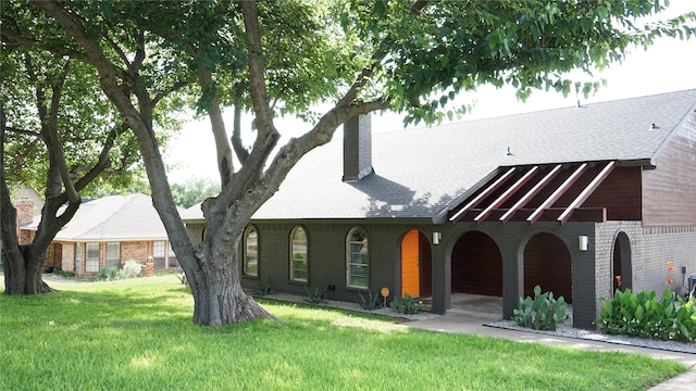7640 Skylake Dr, Fort Worth, TX 76179 - view of front of home with brick siding, roof with shingles, a chimney, and a front lawn