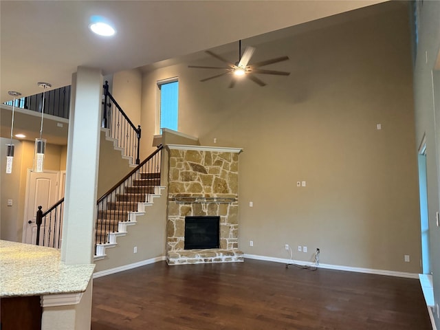 3400 Glen Crest Ln, Denton, TX 76208 - unfurnished living room featuring a high ceiling, wood finished floors, a ceiling fan, stairs, and a fireplace