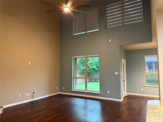 3400 Glen Crest Ln, Denton, TX 76208 - unfurnished living room featuring a ceiling fan, a high ceiling, baseboards, and wood finished floors