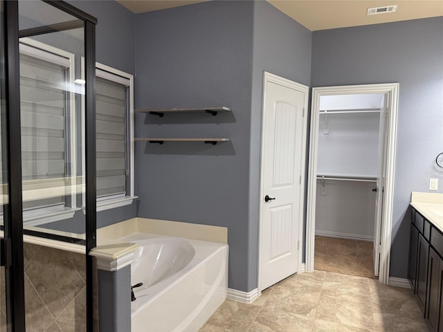 3400 Glen Crest Ln, Denton, TX 76208 - bathroom featuring vanity, a bath, and a walk in closet