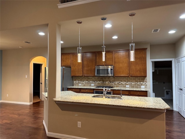 3400 Glen Crest Ln, Denton, TX 76208 - kitchen featuring stainless steel appliances, arched walkways, a sink, baseboards, and tasteful backsplash