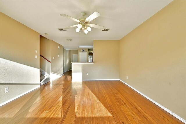 6917 Tessla Dr, Dallas, TX 75241 - empty room with wood finished floors, ceiling fan, baseboards, and stairway