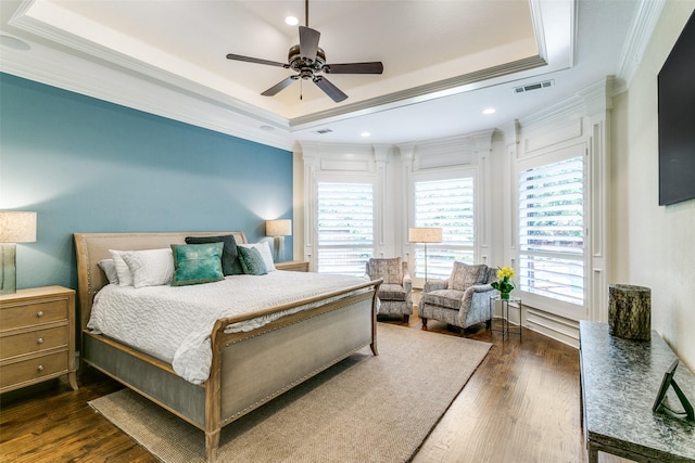 bedroom with a tray ceiling, ornamental molding, dark wood-type flooring, recessed lighting, and a ceiling fan