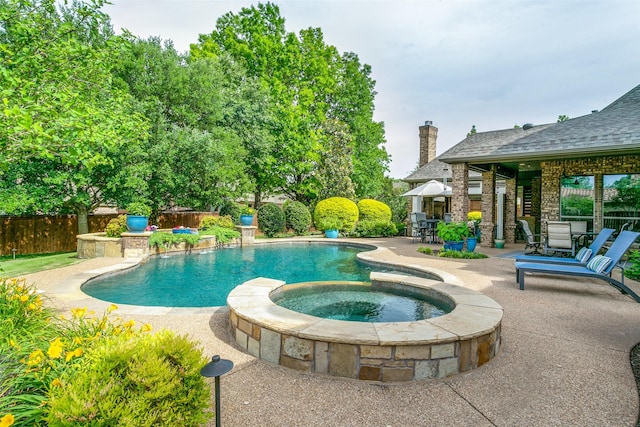 view of swimming pool with a patio, fence, a pool with connected hot tub, and outdoor dining area