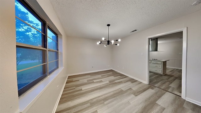 108 Meadowcrest Dr, Desoto, TX 75115 - unfurnished dining area with a textured ceiling, a chandelier, wood finished floors, and baseboards