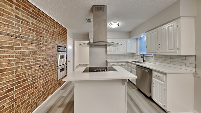 108 Meadowcrest Dr, Desoto, TX 75115 - kitchen with appliances with stainless steel finishes, island exhaust hood, a sink, light wood finished floors, and brick wall