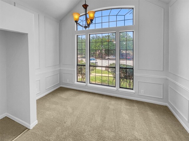2303 Ox Bow Ct, Arlington, TX 76006 - unfurnished dining area with a decorative wall, plenty of natural light, carpet floors, a chandelier, and lofted ceiling