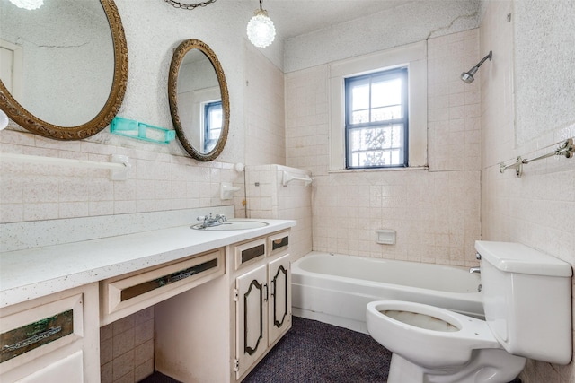full bathroom featuring tile walls, toilet, vanity, and bathtub / shower combination