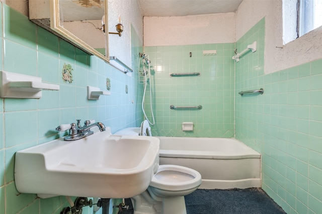 full bath with tile walls, toilet, shower / bath combination, and a sink