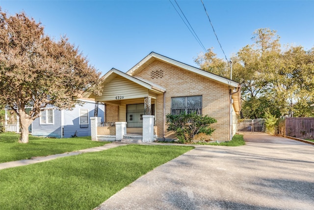 bungalow-style house with a porch, brick siding, and driveway