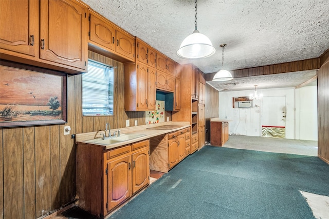 kitchen featuring a sink, carpet floors, pendant lighting, light countertops, and a textured ceiling
