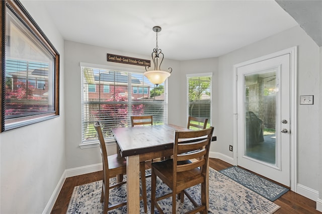 dining area with dark wood-style flooring and baseboards