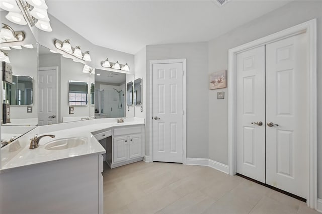 full bath with a shower stall, two vanities, baseboards, and tile patterned floors