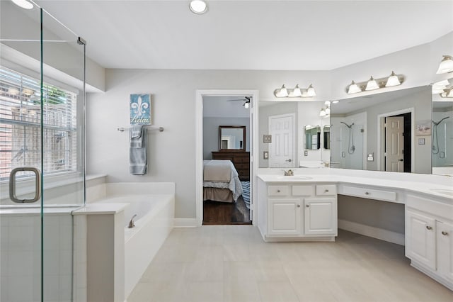 ensuite bathroom with a stall shower, a bath, double vanity, a ceiling fan, and baseboards