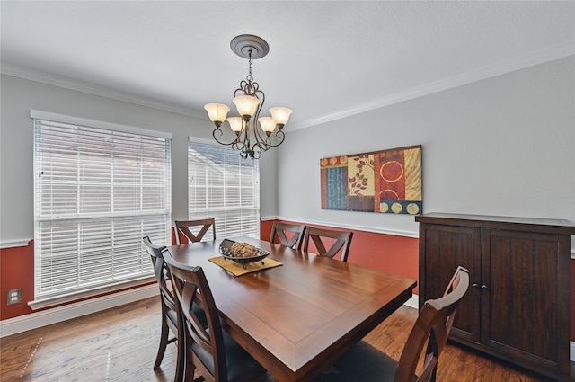 dining space with crown molding, a chandelier, wood finished floors, and baseboards
