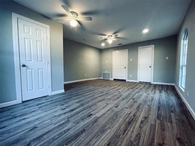 1314 Dewberry St, Wilmer, TX 75172 - unfurnished bedroom featuring dark wood-type flooring, baseboards, a ceiling fan, and multiple closets