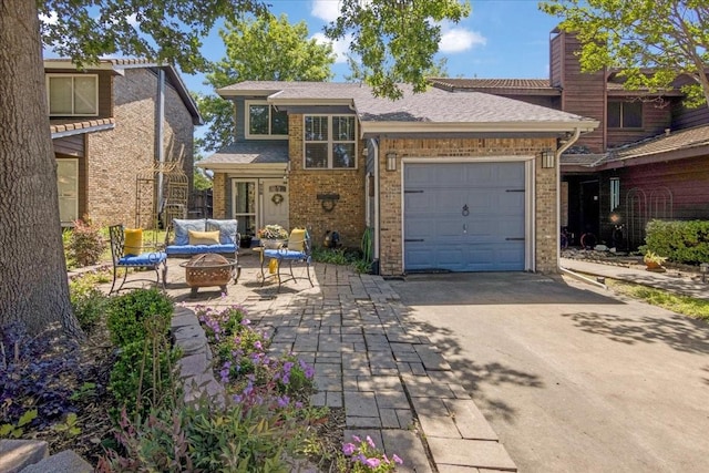 228 Mccarley Pl, Mckinney, TX 75071 - view of front facade with concrete driveway, a garage, an outdoor living space with a fire pit, and brick siding
