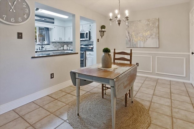 228 Mccarley Pl, Mckinney, TX 75071 - dining room with light tile patterned floors, a chandelier, and wainscoting