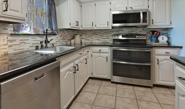 228 Mccarley Pl, Mckinney, TX 75071 - kitchen featuring appliances with stainless steel finishes, a sink, light tile patterned floors, tasteful backsplash, and white cabinetry