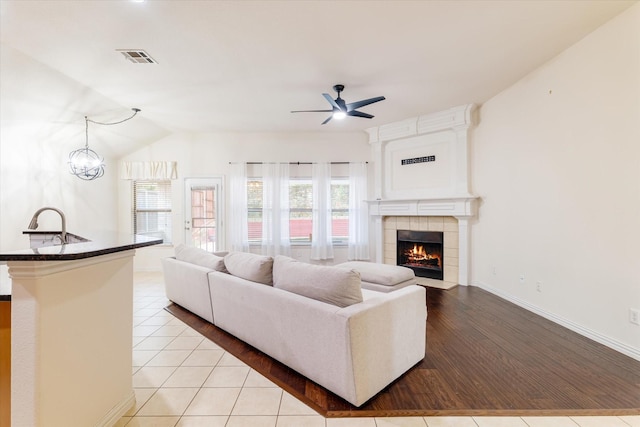 505 Osage Dr, Mckinney, TX 75071 - living room with a ceiling fan, a tiled fireplace, baseboards, and light tile patterned floors