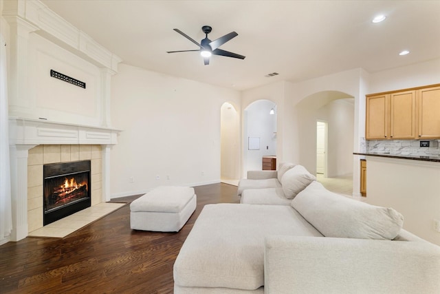 505 Osage Dr, Mckinney, TX 75071 - living room with arched walkways, a ceiling fan, recessed lighting, wood finished floors, and a tiled fireplace