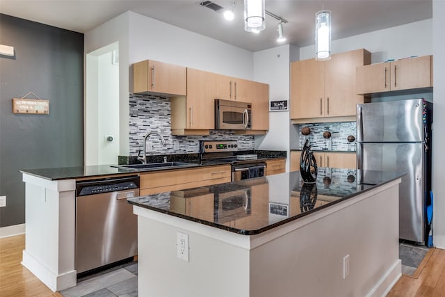 4414 Cedar Springs Rd Unit 209, Dallas, TX 75219 - kitchen with appliances with stainless steel finishes, a sink, dark stone counters, light wood-type flooring, and tasteful backsplash