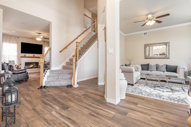 7013 Caldwell Ln, Plano, TX 75025 - living room featuring ceiling fan, stairs, wood finished floors, baseboards, and a glass covered fireplace