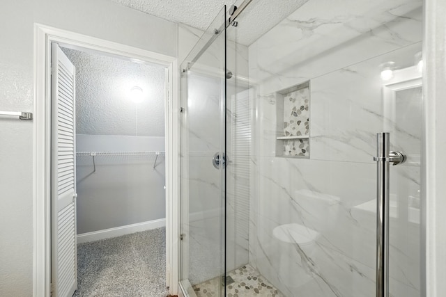 2312 Balsam Dr Unit A206, Arlington, TX 76006 - bathroom featuring a textured ceiling, a marble finish shower, and a walk in closet