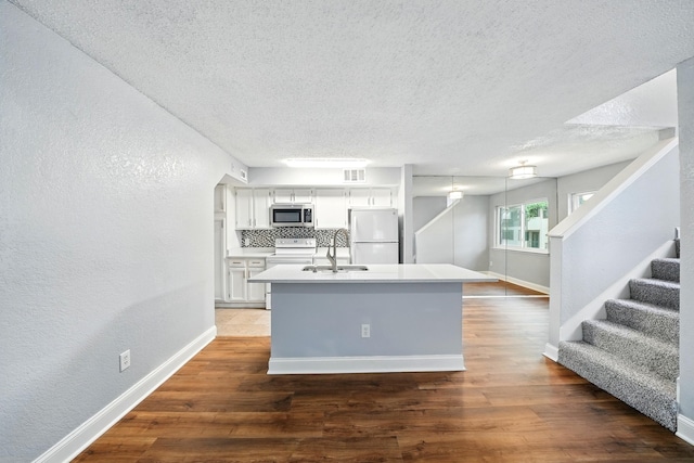 2312 Balsam Dr Unit A206, Arlington, TX 76006 - kitchen with white appliances, a sink, a textured ceiling, baseboards, and a textured wall