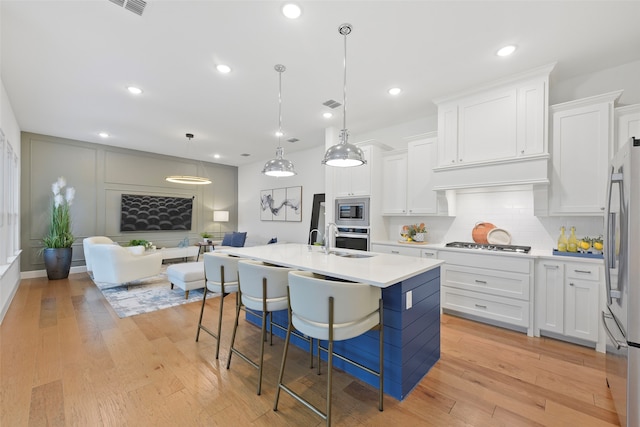 13037 Cabana Dr, Frisco, TX 75035 - kitchen with appliances with stainless steel finishes, white cabinetry, light countertops, a kitchen breakfast bar, and tasteful backsplash