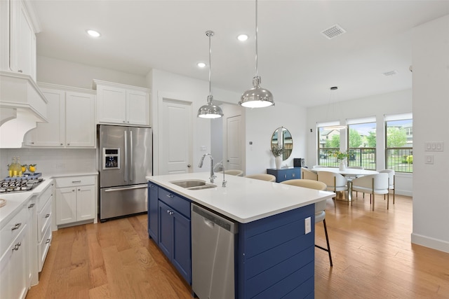 13037 Cabana Dr, Frisco, TX 75035 - kitchen featuring appliances with stainless steel finishes, a sink, blue cabinetry, white cabinetry, and recessed lighting