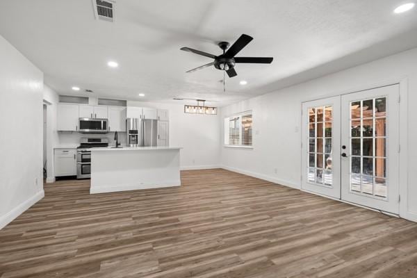 2309 Ruby Rd, Irving, TX 75060 - unfurnished living room featuring recessed lighting, baseboards, french doors, wood finished floors, and ceiling fan