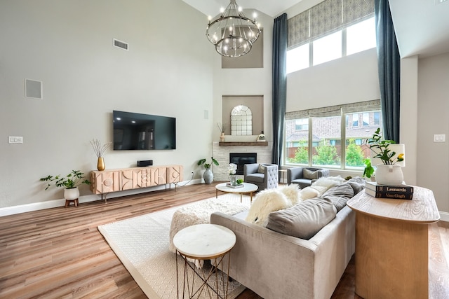 4533 Cheetah Trl, Frisco, TX 75034 - living area with a towering ceiling, baseboards, a chandelier, wood finished floors, and a fireplace