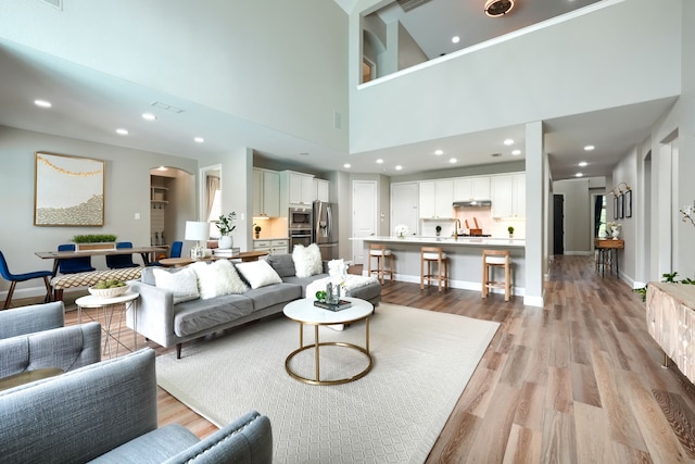 4533 Cheetah Trl, Frisco, TX 75034 - living area featuring light wood finished floors, baseboards, a towering ceiling, and recessed lighting