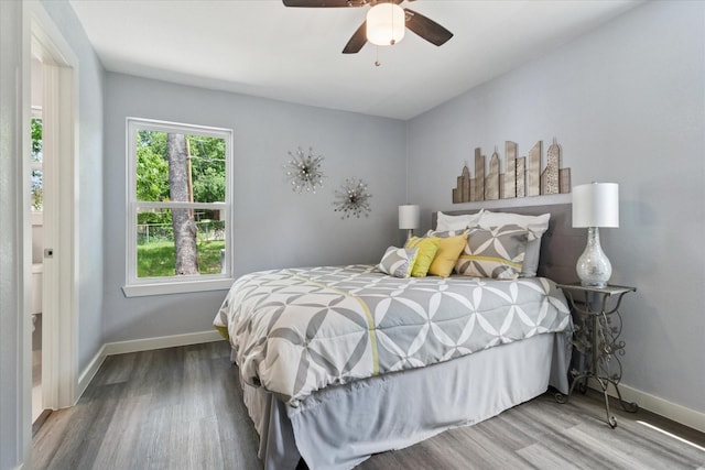 bedroom with wood finished floors, baseboards, and a ceiling fan