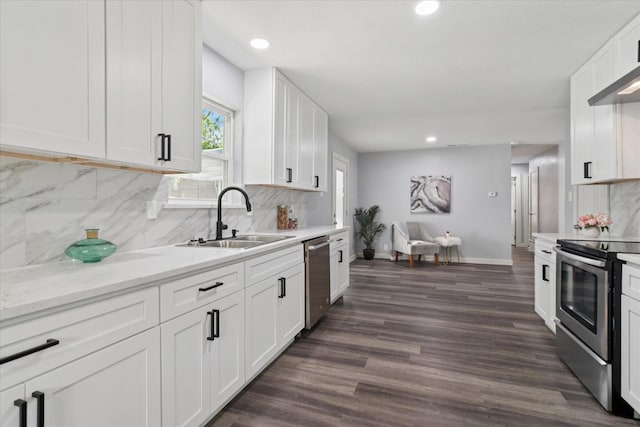 kitchen featuring appliances with stainless steel finishes, a sink, recessed lighting, baseboards, and white cabinets