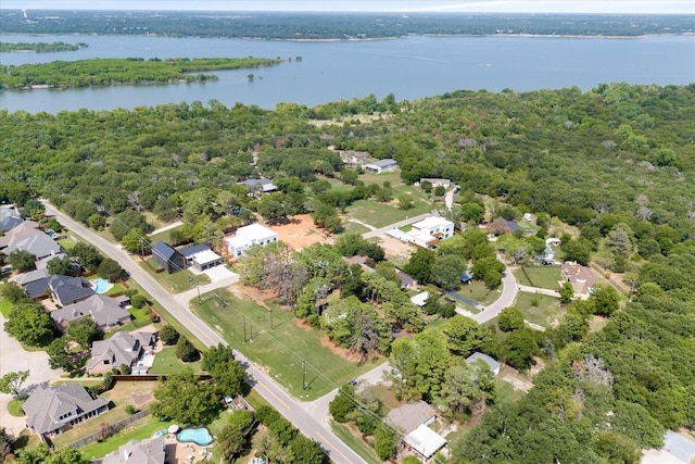 aerial overview of property's location with a nearby body of water, a heavily wooded area, and nearby suburban area