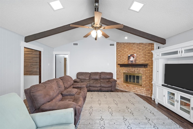 308 W Spring Valley Dr, Hewitt, TX 76643 - living area featuring dark wood-type flooring, a textured ceiling, a ceiling fan, a fireplace, and wood walls