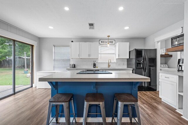 308 W Spring Valley Dr, Hewitt, TX 76643 - kitchen featuring black appliances, a kitchen island, decorative backsplash, white cabinets, and recessed lighting