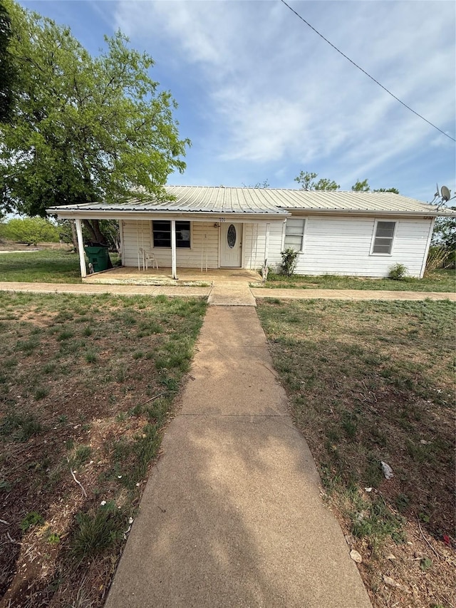 701 Perry, Santa Anna, TX 76878 - view of front of house with metal roof and a front yard