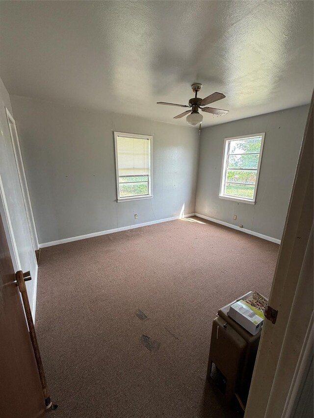 701 Perry, Santa Anna, TX 76878 - carpeted empty room featuring baseboards, a textured ceiling, and ceiling fan